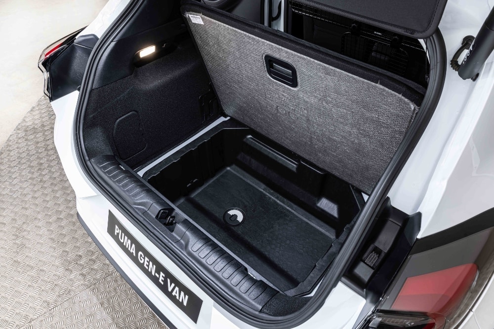 Κρυφός αποθηκευτικός χώρος κάτω από το δάπεδο του πορτμπαγκάζ του Ford Puma Gen-E Van, ανοιχτός και άδειος.