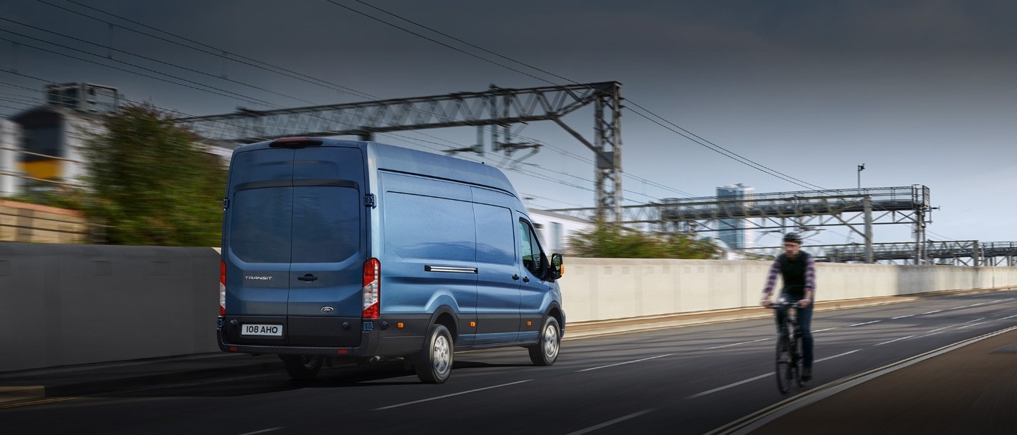 New Blue Transit Van rear view driving on road