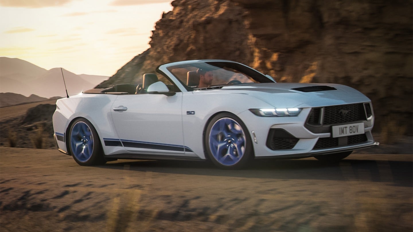 Silver mustang driving next to a mountain