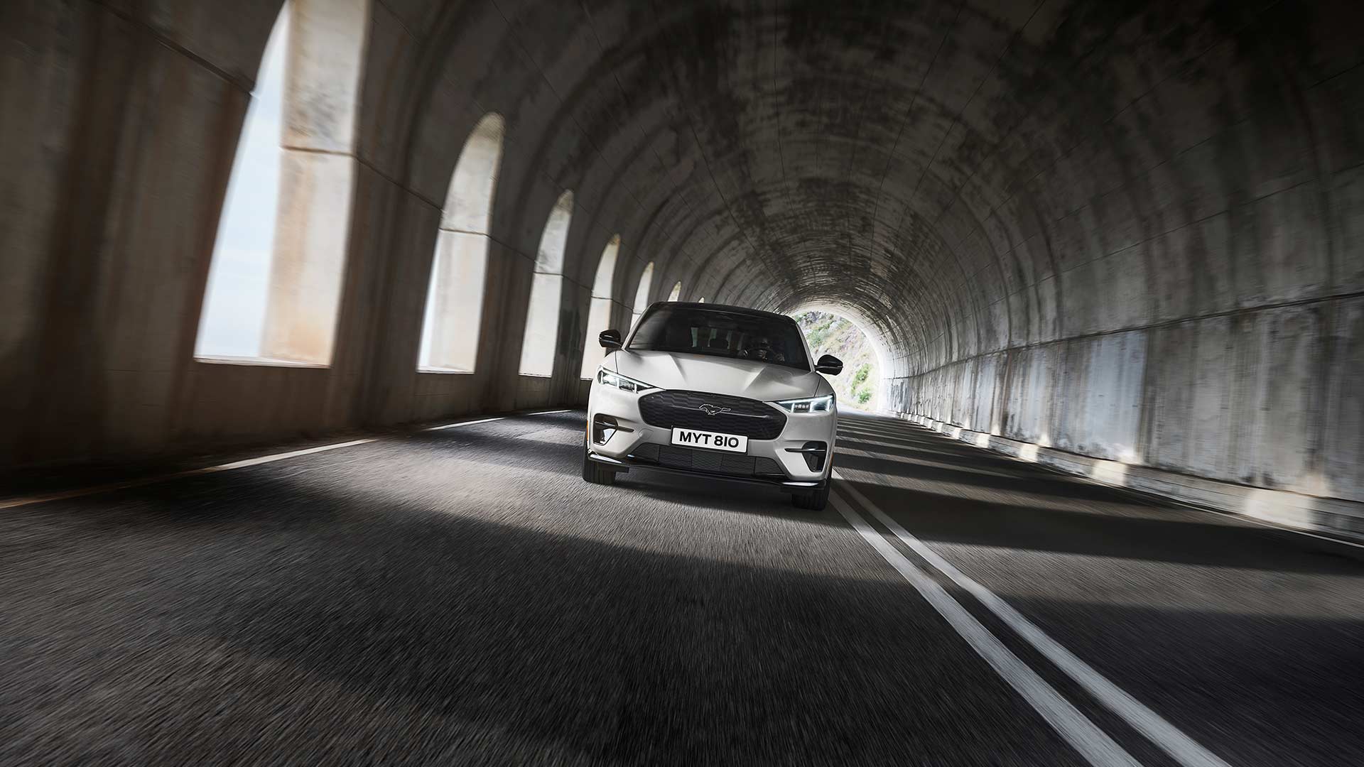 Ένα ασημί ηλεκτρικό Ford Mustang Mach-E οδηγείται μέσα σε τούνελ.
