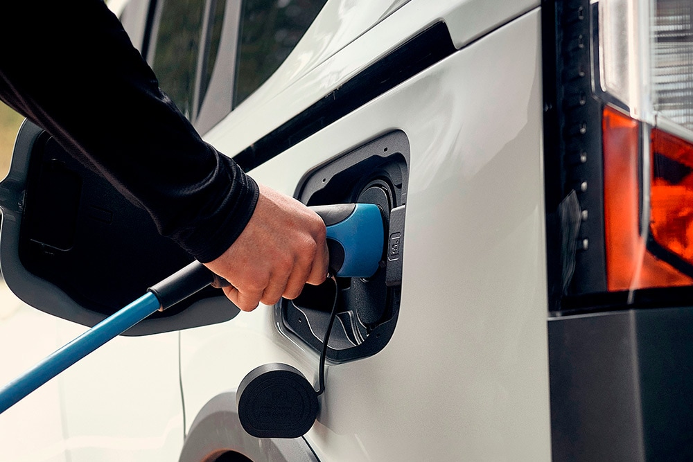 Ένα άτομο συνδέει ένα ηλεκτρικό Ford σε καλώδιο φόρτισης.