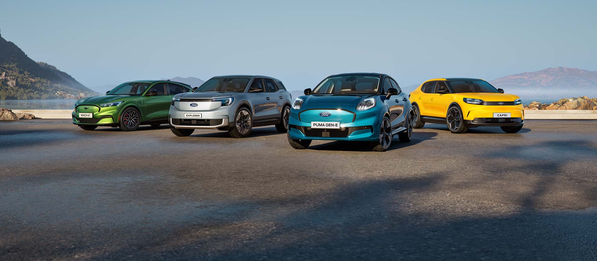 Μια συλλογή από διαφορετικά ηλεκτρικά αυτοκίνητα Ford σταθμευμένα σε ένα δύσβατο παραλιακό τοπίο.