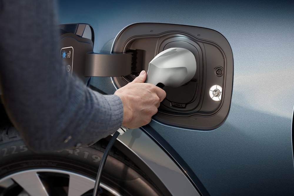 Ένα κοντινό πλάνο ενός ατόμου που φορτίζει ένα ηλεκτρικό όχημα Ford.