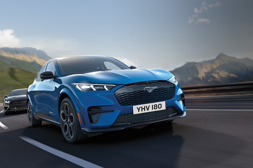 Μία μπλε Ford Mustang Mach-E οδηγεί σε αυτοκινητόδρομο