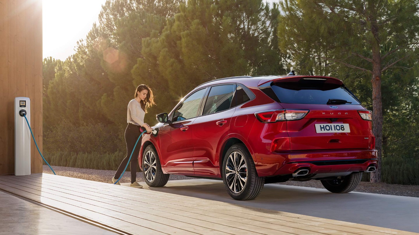 Woman charging a Ford Kuga Plug-In Hybrid at home