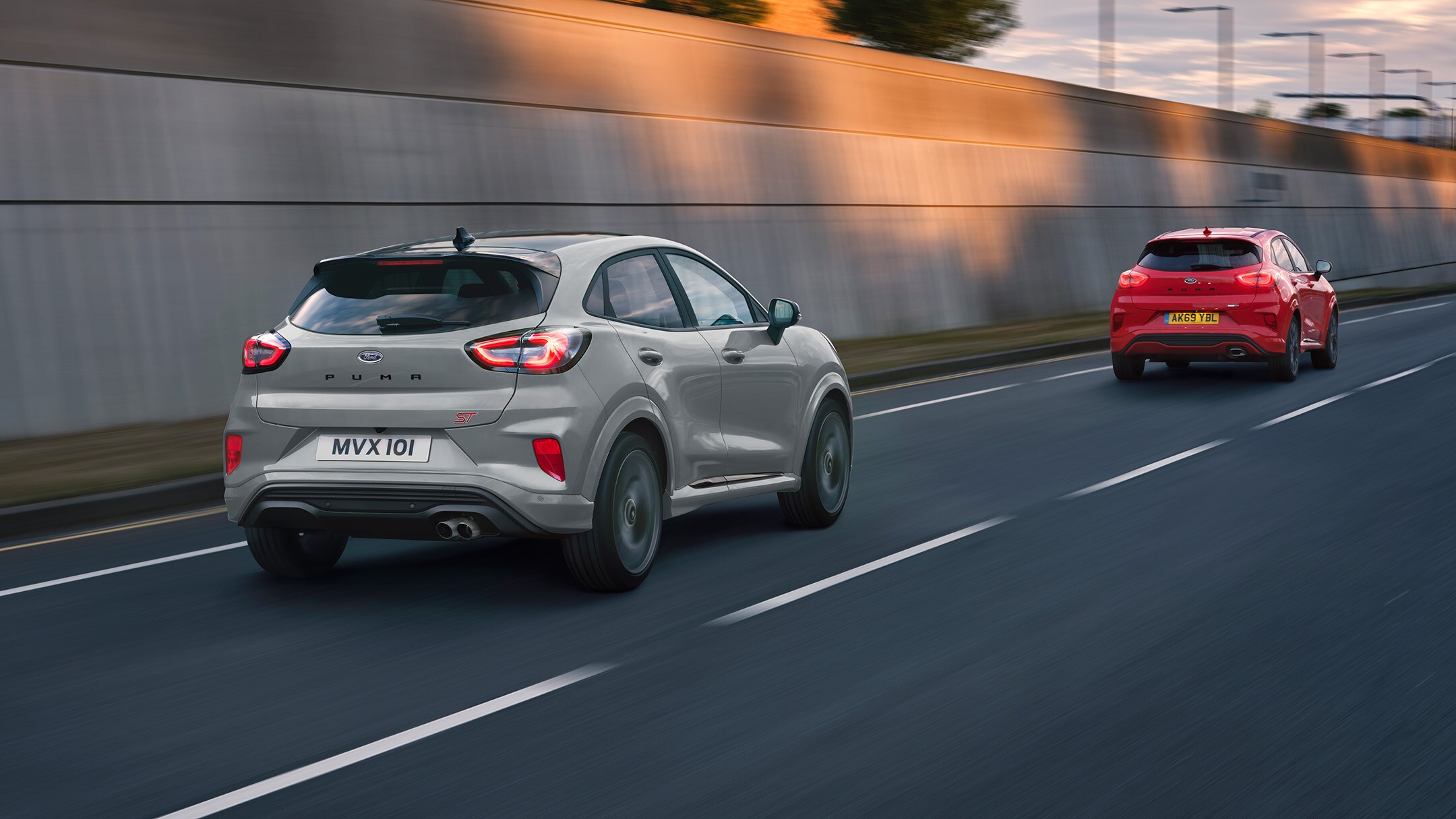 Rear view of a red and silver Ford Puma ST driving along a road