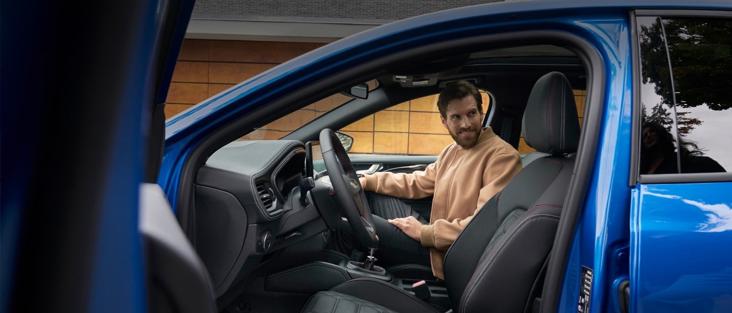 Man sitting in the passenger seat of Ford Focus with open front door