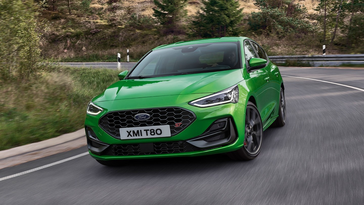 A green Focus ST making a turn on a road