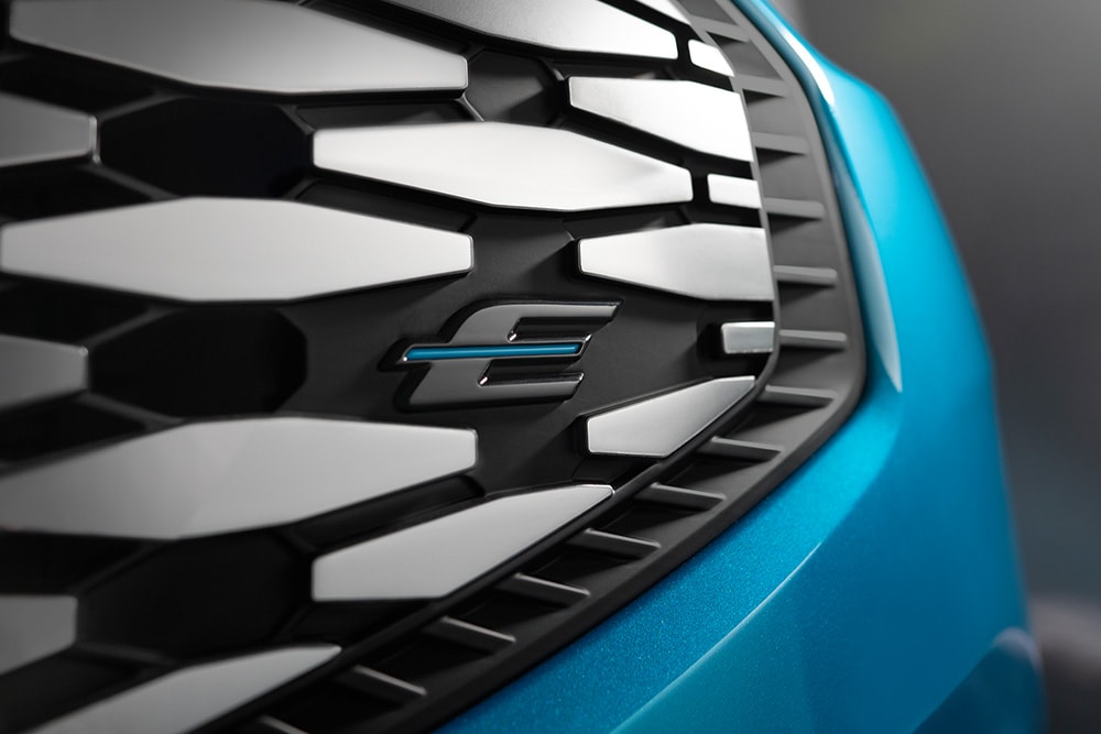 Κοντινή άποψη της μάσκας του Ford E-Tourneo Custom, με το μπλε λογότυπο «E» αποκλειστικά για ηλεκτρικά οχήματα Ford.