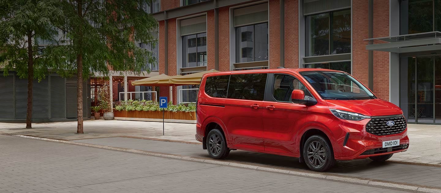 Κόκκινο Ford Tourneo Custom σταθμευμένο σε δρόμο στην πόλη.