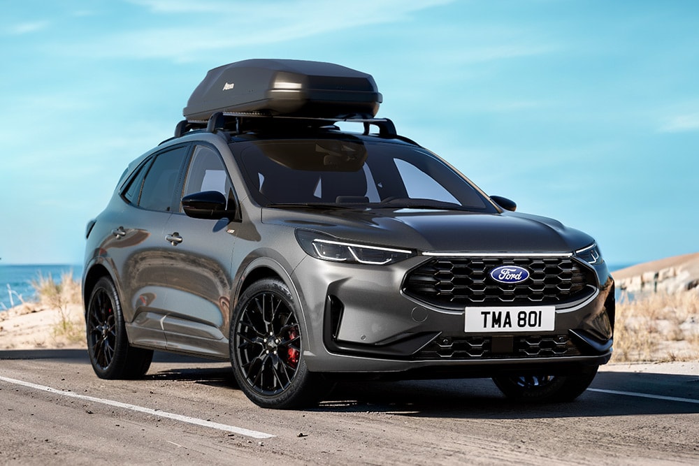 Ένα γκρι Ford Kuga Black Package, με κοντινό πλάνο των μαύρων ζαντών αλουμινίου 20 ιντσών, μαύρες εξωτερικές λεπτομέρειες και μπαγκαζιέρα οροφής.