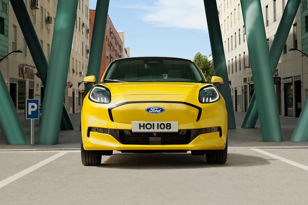 Front view of a yellow Puma Gen-E driving through the city street.