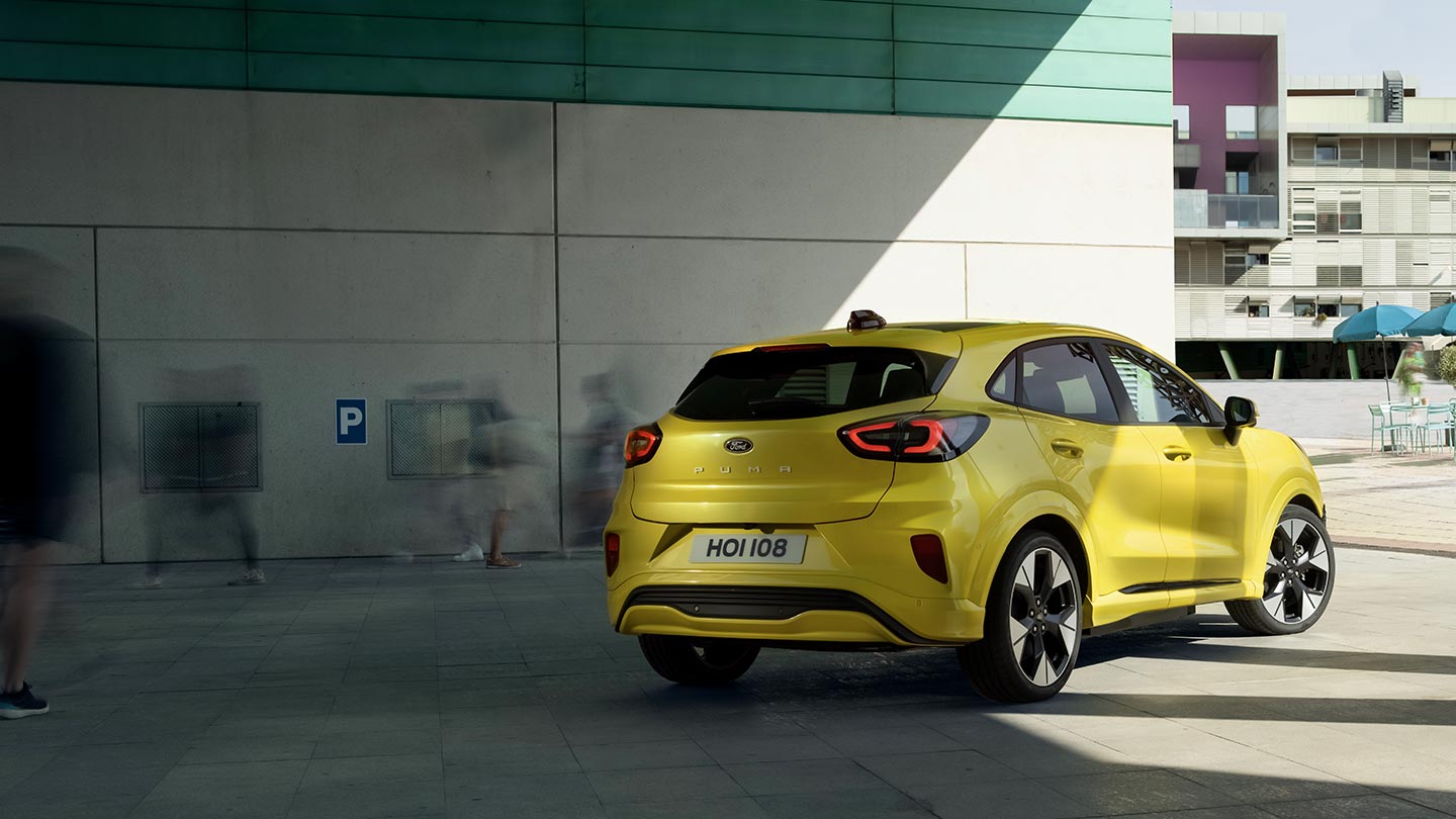 Η πίσω άποψη ενός ηλεκτρικού Ford Puma Gen-E® που είναι σταθμευμένο κάτω από μια γέφυρα.