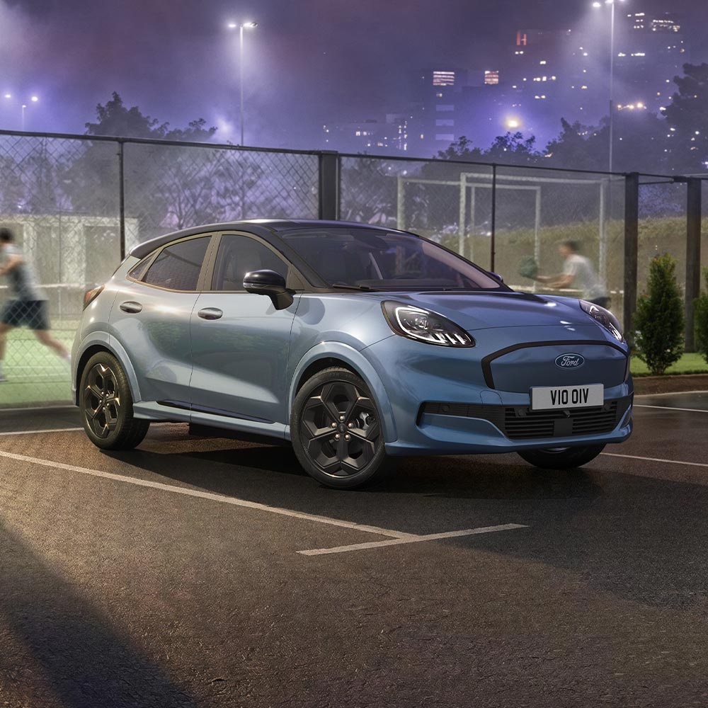 Ένα Ford Puma Gen-E limited edition σε Vapour Blue με τεχνολογία BlueCruise σταθμευμένο δίπλα σε ένα υπαίθριο γήπεδο padel.