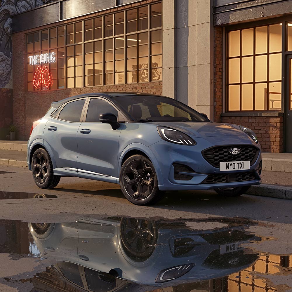 Ένα Ford Puma limited edition σε χρώμα Vapour Blue σταθμευμένο σε έναν αμυδρά φωτισμένο δρόμο της πόλης τη νύχτα.