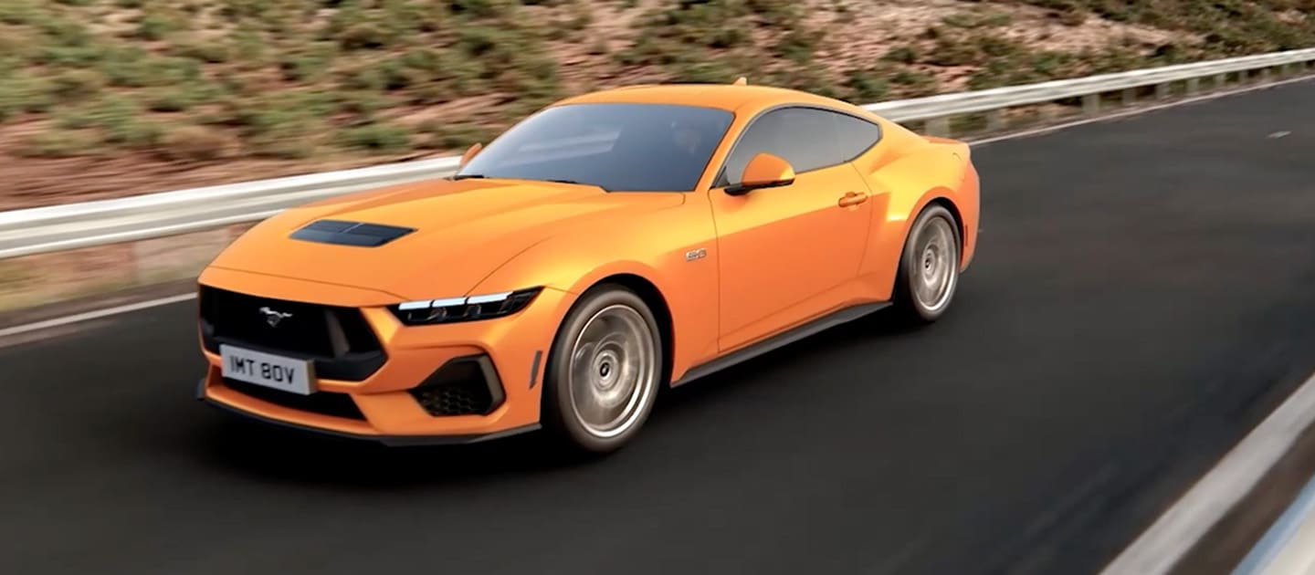 Ford Mustang GT Fastback σε χρώμα Orange Fury που κινείται σε έναν ορεινό δρόμο