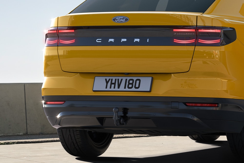 Πίσω όψη ενός κίτρινου Ford Capri® που κινείται σε δρόμο μέσα στην πόλη.