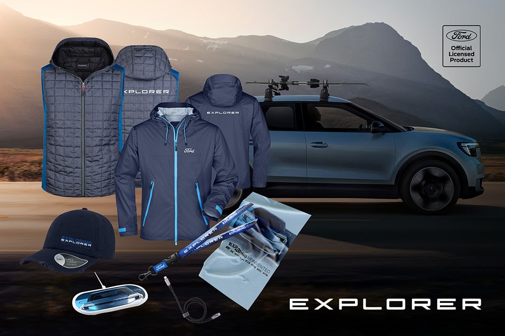 Μπλε προϊόντα Ford Explorer, όπως μπουφάν, καπέλο και άλλα αξεσουάρ, εκτεθειμένα μπροστά από ένα Ford Explorer με χρώμα Arctic Blue.