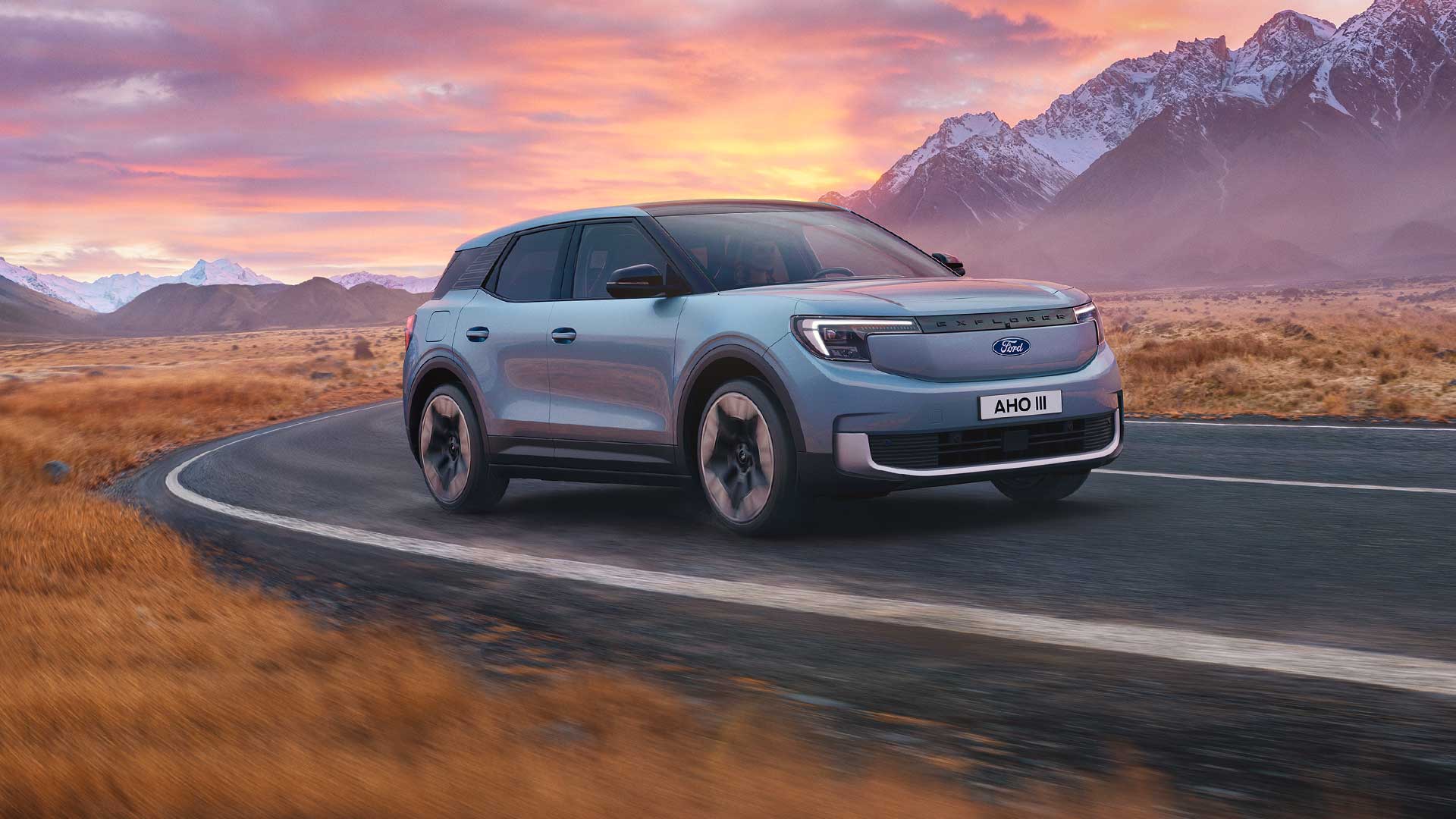 Το νέο αμιγώς ηλεκτρικό Ford Explorer® κινείται σε έναν ορεινό δρόμο το ηλιοβασίλεμα.