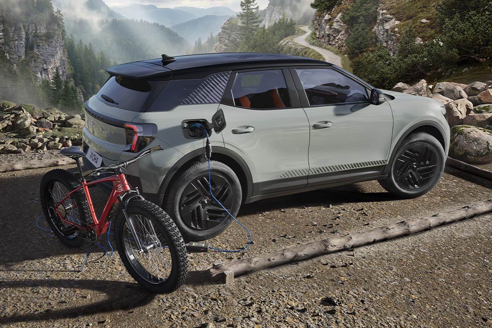 Ένα ηλεκτρικό ποδήλατο φορτίζει από ένα Ford Explorer®, με ορεινό τοπίο στο φόντο.