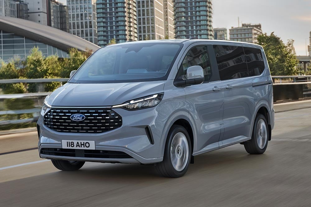 Ασημί Ford Tourneo Custom που κινείται σε έναν δρόμο στην πόλη.