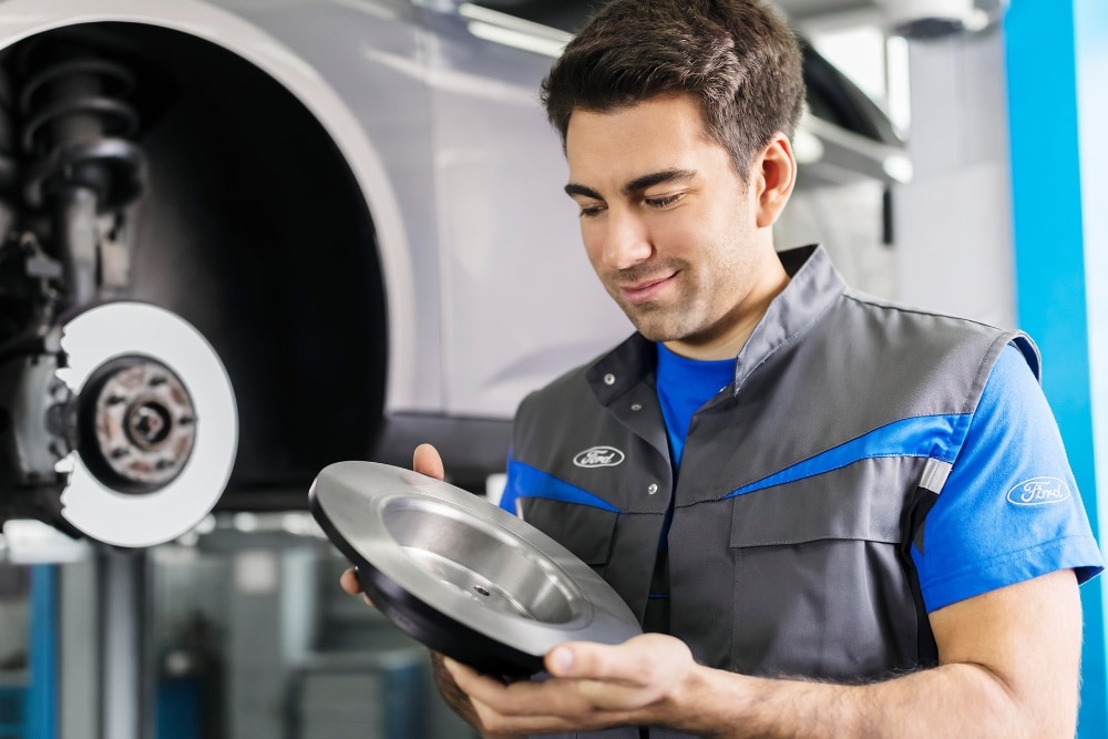 Τεχνικός Ford κρατάει δισκόπλακα από τα εμπρόσθια φρένα