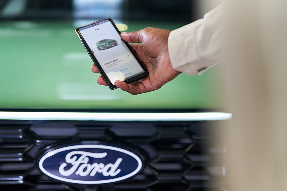 Άνδρας που κοιτάζει την εφαρμογή Ford σε ένα smartphone
