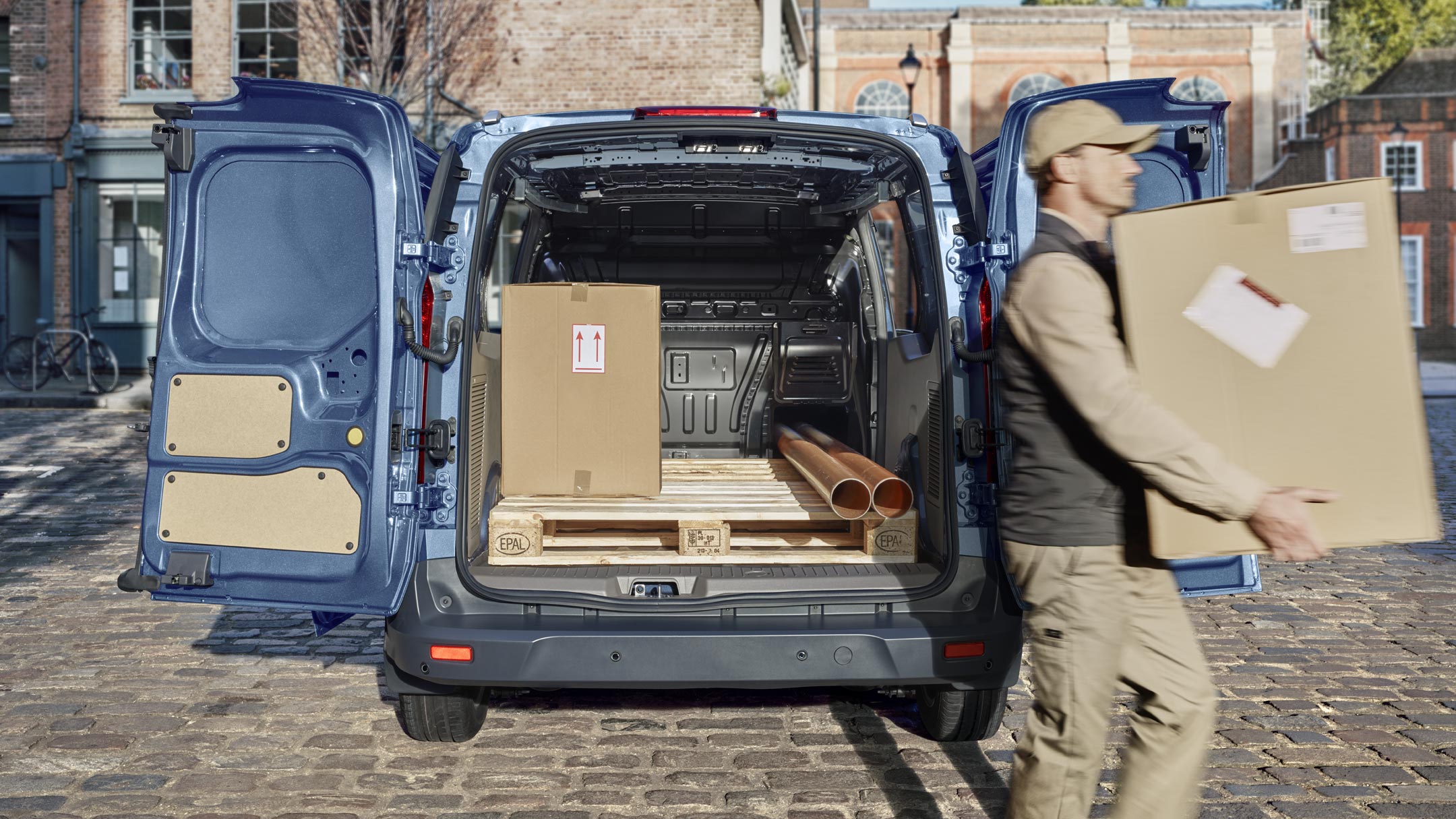 Ford Transit Connect with open back door and person moving boxes