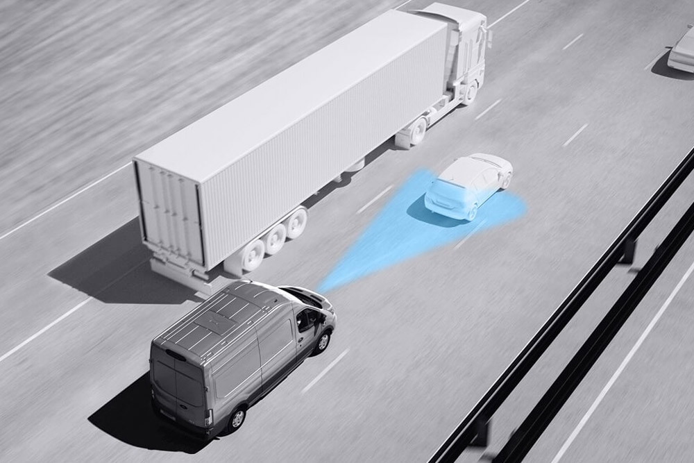 Σχέδιο σε αποχρώσεις του γκρι ενός Ford Transit van με μπλε γραμμές στον δρόμο που δείχνουν τη χρήση προηγμένων συστημάτων υποβοήθησης οδηγού.