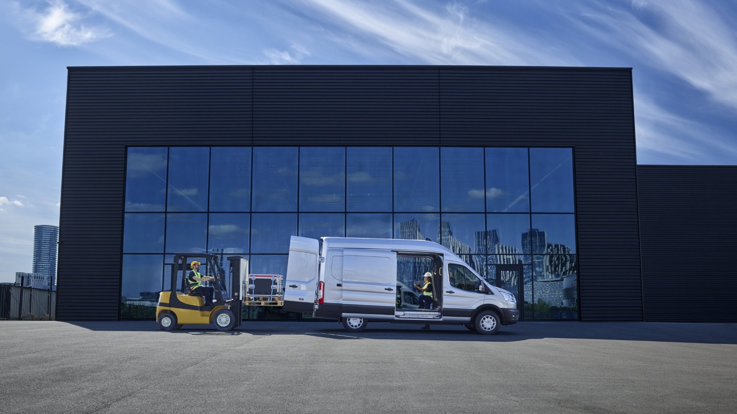 New Ford E-Transit standing in front of glass building side view with side door open