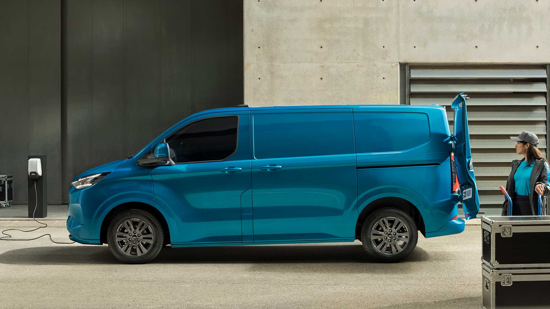 Μπλε ηλεκτρικό van Ford E-Transit Custom που φορτίζει.