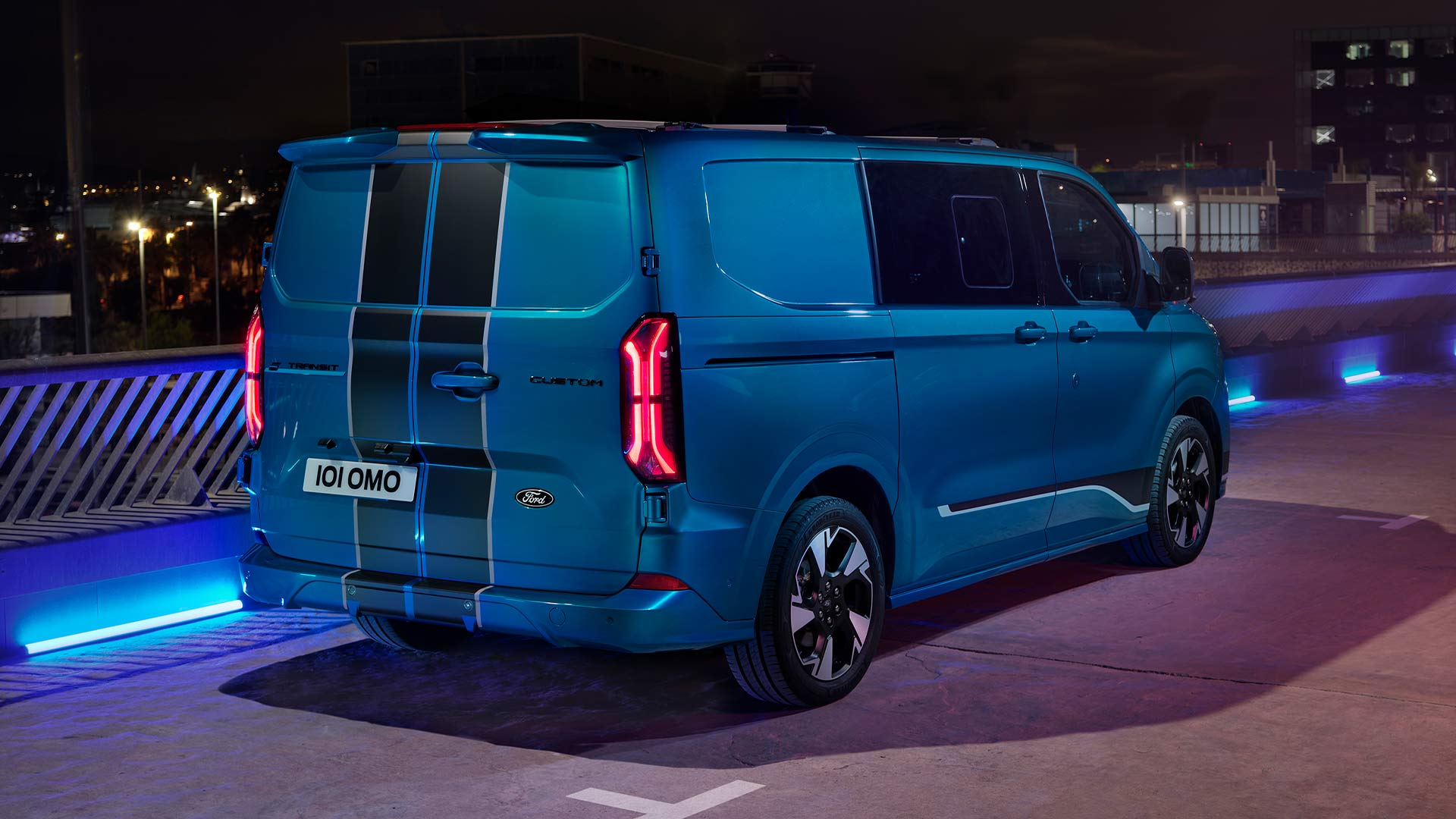 Πίσω άποψη ενός μπλε ηλεκτρικού Ford E-Transit Custom Sport Double Cab-in-Van.