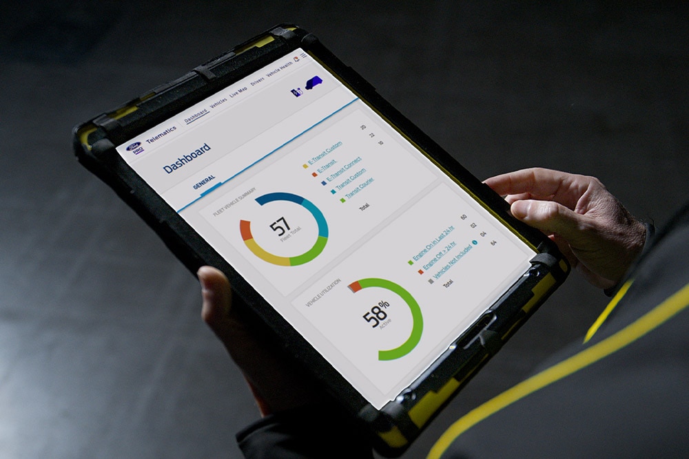 Άτομο που κρατάει ένα tablet όπου φαίνονται τα δεδομένα του οχήματος Ford Pro.