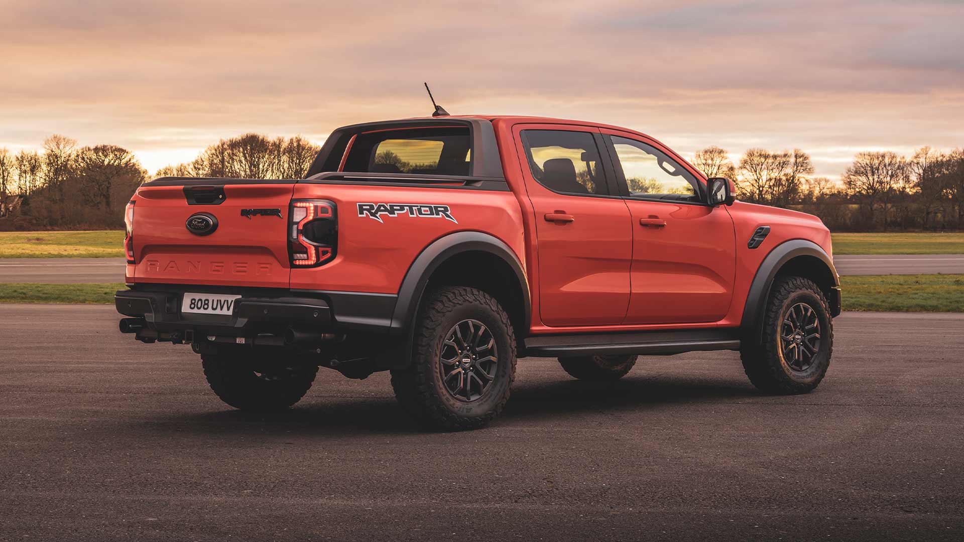 Πίσω όψη ενός Ford Ranger Raptor σε Code Orange σταθμευμένο σε πίστα.