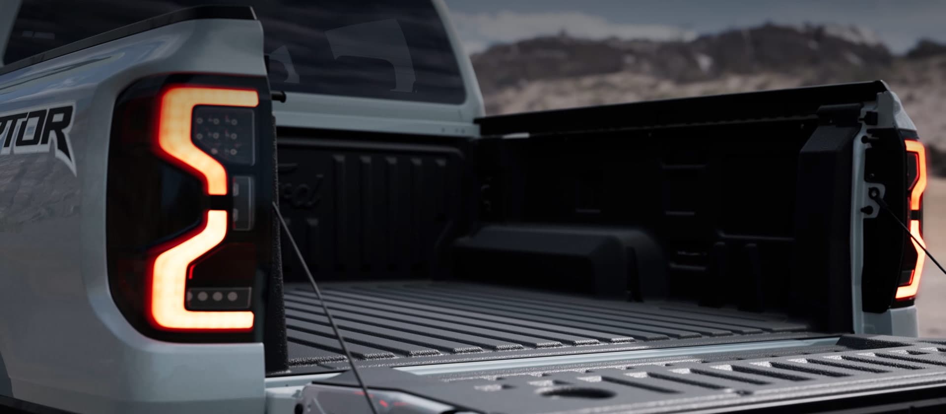 Silver Ford Ranger Raptor truck bed with an open tailgate.