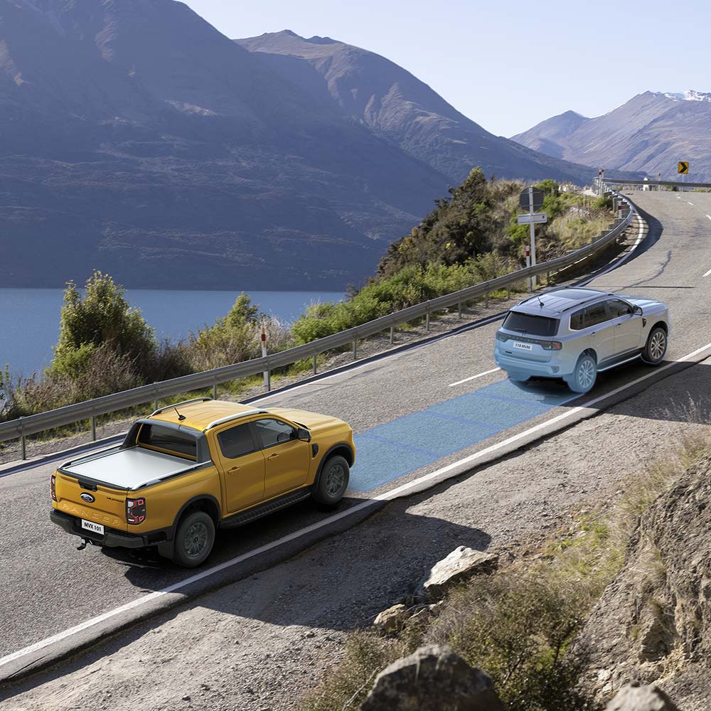 Ένα Ford Ranger σε Cyber Orange που χρησιμοποιεί το σύστημα ελέγχου ταχύτητας Adaptive Cruise Control καθώς κινείται.