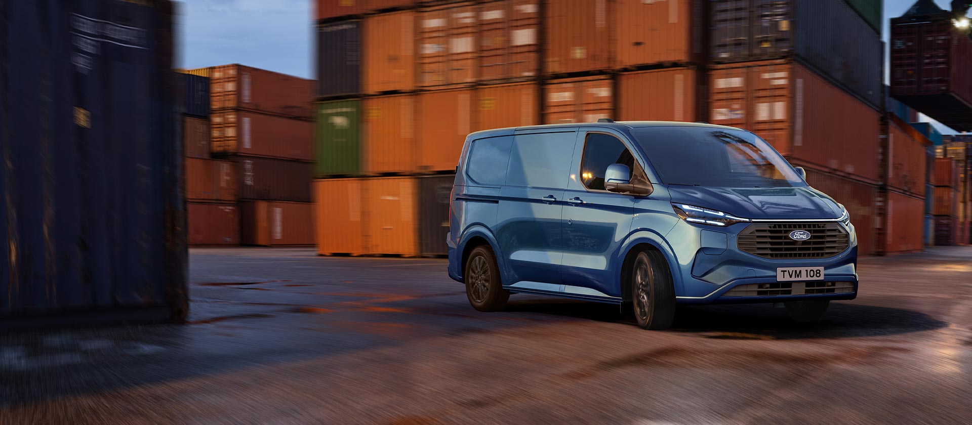 Μπλε Ford Transit Custom Plug-In Hybrid van που περνάει από μια προβλήτα.