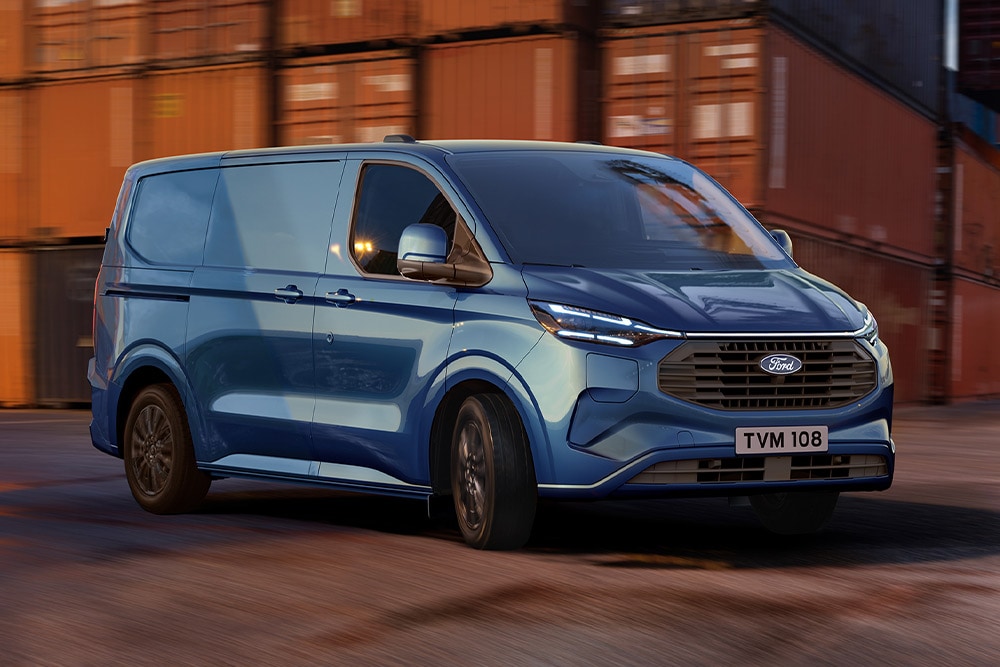 Μπλε Ford Transit Custom Plug-in υβριδικό van που περνάει από μια προβλήτα.