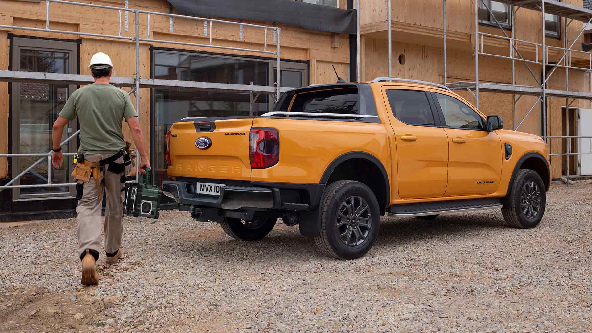 Πίσω όψη τριών τετάρτων του κίτρινου Ford Ranger Double Cab Wildtrak σε εργοτάξιο.