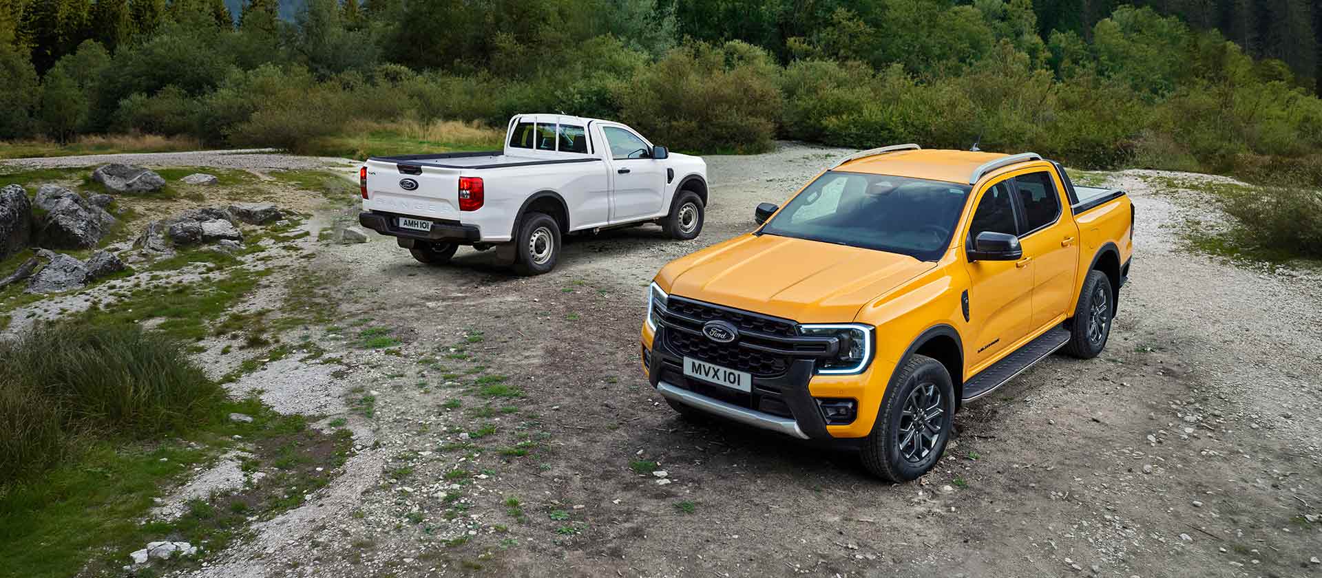 Ένα λευκό Ford Ranger και ένα κίτρινο Ford Ranger είναι σταθμευμένα σε μια βραχώδη πλευρά του δρόμου.