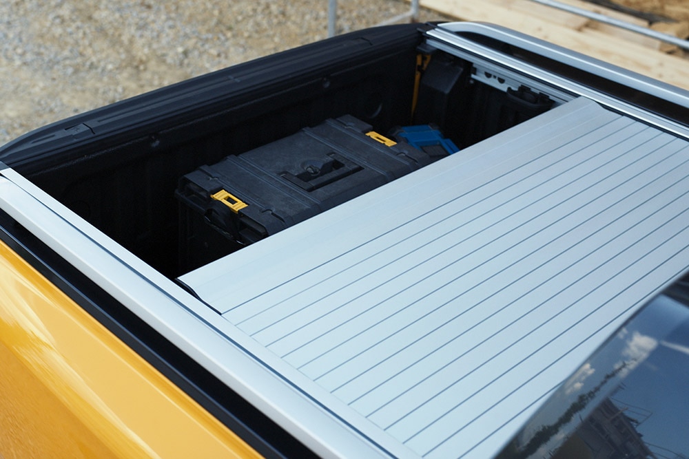 Ένας εργάτης ανεβαίνει στο ενσωματωμένο πίσω σκαλοπάτι του Ford Ranger.