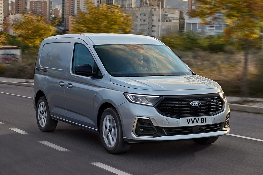 Ένα Ford Transit Connect καθώς κινείται σε μια πόλη, στο οποίο εμφανίζεται ο περιβάλλων φωτισμός ομίχλης με λεπτομέρειες χρωμίου και οι αυτόματοι προβολείς.