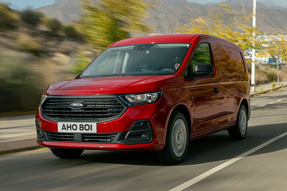 Ένα Ford Transit Connect που κινείται σε έναν δρόμο, στο οποίο φαίνεται η εμπρός μάσκα και οι αυτόματοι προβολείς.
