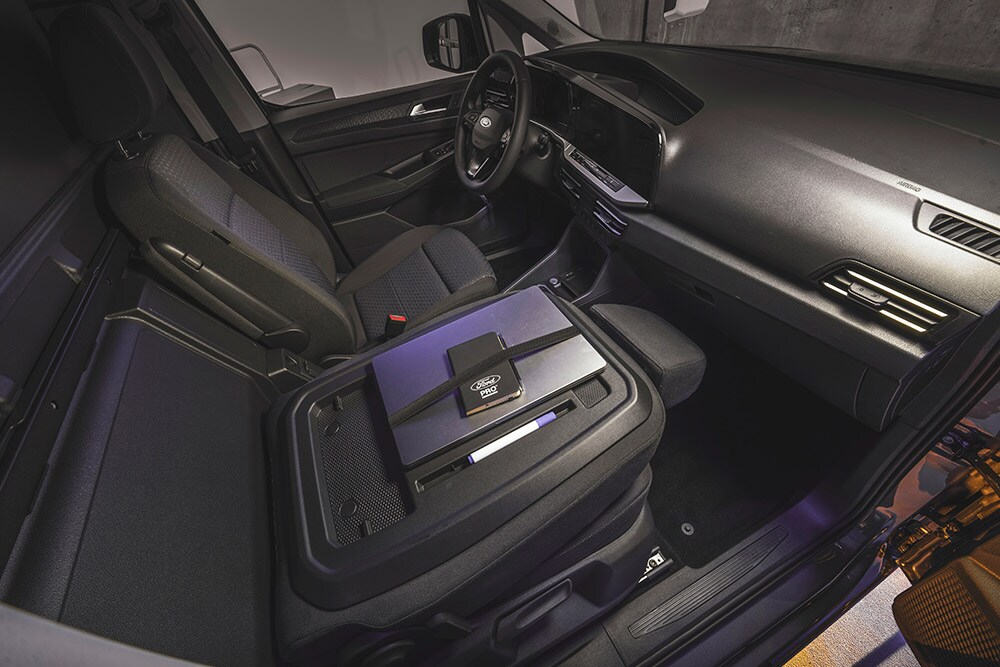 Εσωτερικό ενός Ford Transit Connect όπου φαίνονται το ταμπλό, τα καθίσματα, ένας φορητός υπολογιστής και ένα τηλέφωνο στην κεντρική κονσόλα.