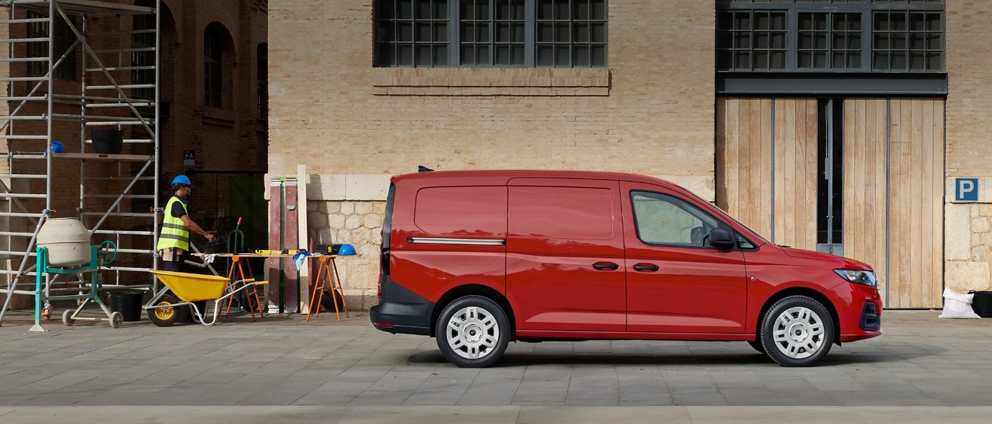 Νέο Ford Transit Connect χρώματος Maple Red, σταθμευμένο σε εργοτάξιο όπου φαίνεται η πλαϊνή πόρτα φόρτωσης.