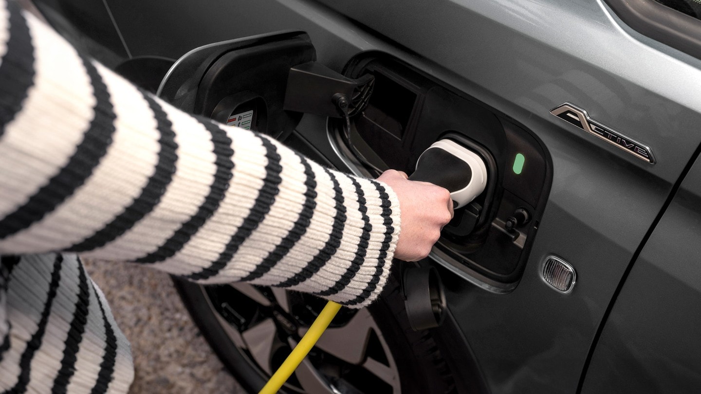 Καλώδιο φόρτισης συνδεδεμένο στη θύρα του Ford Tourneo Connect χρώματος Boundless Blue.