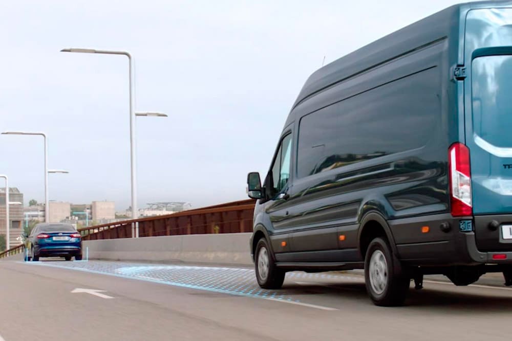 Μπλε Ford Transit Van με μπλε γραμμές στον δρόμο, που δείχνουν τη χρήση των προηγμένων συστημάτων υποβοήθησης οδηγού.