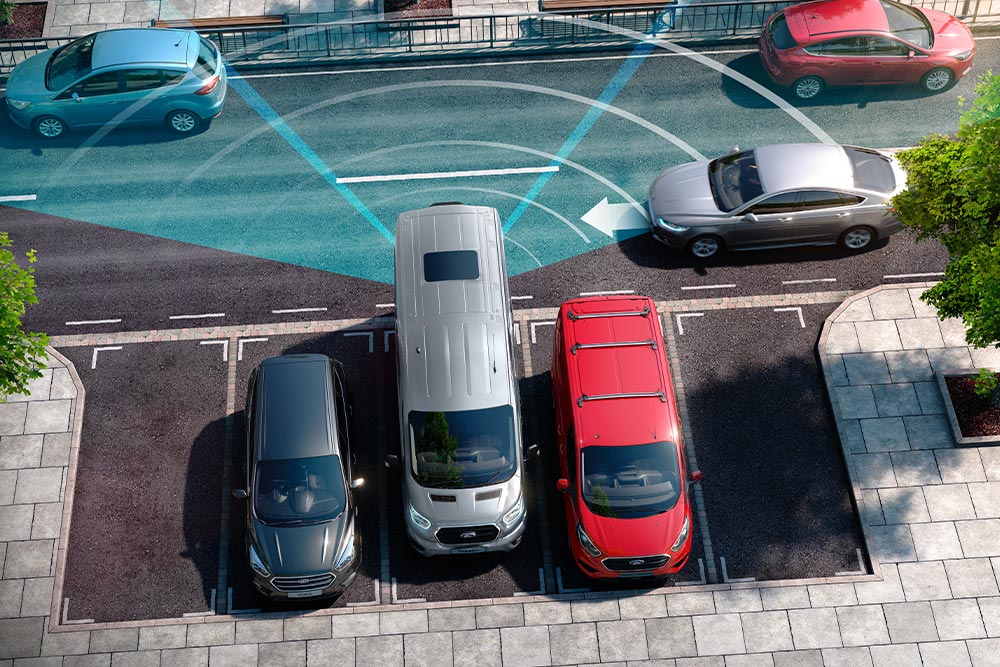 Ασημί Ford Transit Van που κάνει όπισθεν, με μπλε γραμμές που απεικονίζουν τη χρήση του πίσω αισθητήρα στάθμευσης. 