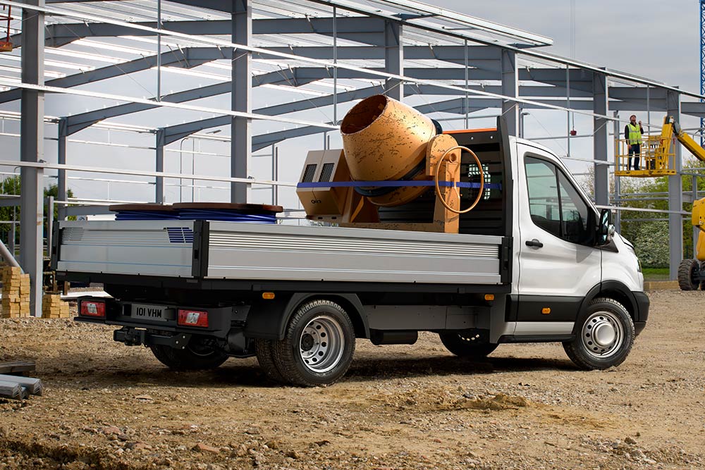 Ford Transit Chassis Cab που μεταφέρει μπετονιέρα στον χώρο φόρτωσης και είναι σταθμευμένο σε ένα εργοτάξιο. 