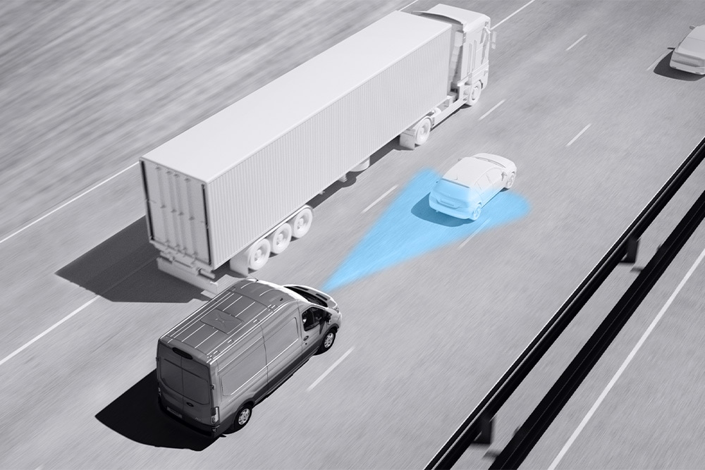 Σχέδιο σε αποχρώσεις του γκρι ενός Ford Transit van με μπλε γραμμές στον δρόμο που δείχνουν τη χρήση προηγμένων συστημάτων υποβοήθησης οδηγού.